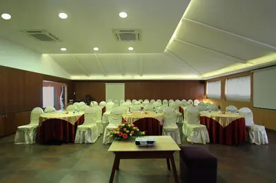a banquet hall with tables and chairs in a room at Silent Shores Resort & Spa in Mysore
