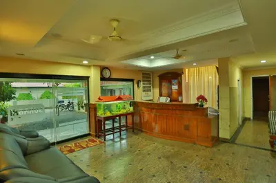 a large living room with a couch and a counter at Surabhi Suites in Angamali