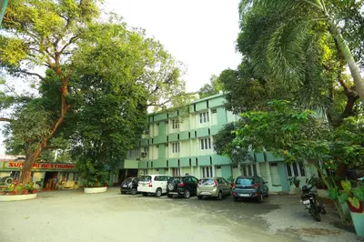 a building with cars parked in a parking lot at Surabhi Suites in Angamali