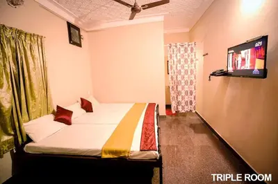 a hotel room with a bed and a tv at Surabhi Suites in Angamali