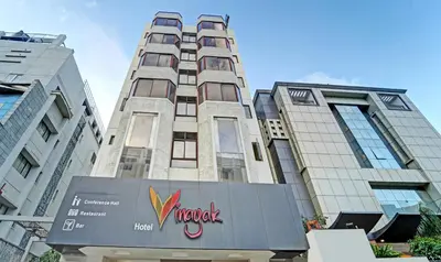 a tall building with a sign in front of it at Treebo Vinayak Inn, 600 Mts From Coimbatore Railway Station in Coimbatore