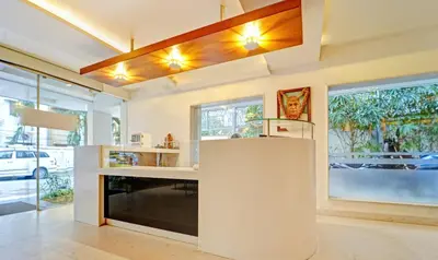 a kitchen with a white counter and some windows at Treebo Vinayak Inn, 600 Mts From Coimbatore Railway Station in Coimbatore
