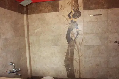 a mural of a woman on a wall in a bathroom at Rustling River Resort in Ooty