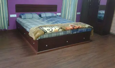 a bed with a wooden frame in a room at Rustling River Resort in Ooty