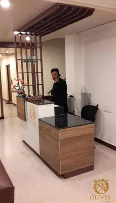 a man talking on a cell phone in an office at Olives Pleasant Stays in Ooty