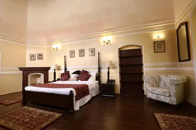 a large bedroom with a bed and a chair at 7 BHK Luxury Heritage Villa - Rock Ooty in Ooty