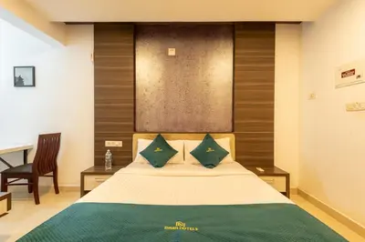 a bedroom with a bed with a desk and a chair at Daan Ambalath Maple Leaves in Guruvāyūr
