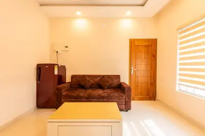 a living room with a couch and a refrigerator at Daan Ambalath Maple Leaves in Guruvāyūr
