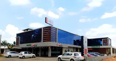 a building with cars parked in front of it at Paddyfield Inn in Mananthavady