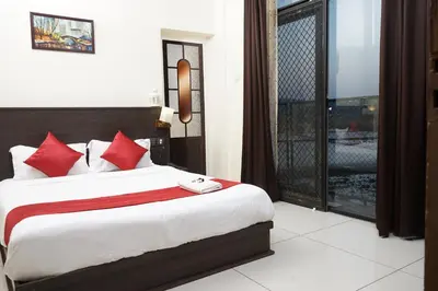 a bedroom with a bed with red pillows and a window at Paddyfield Inn in Mananthavady