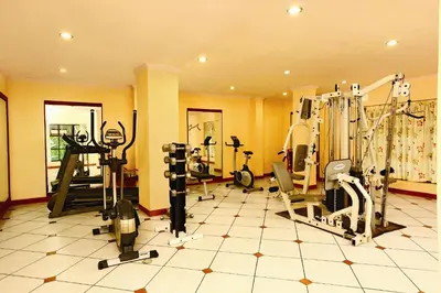 a gym with several treadms and machines in a room at Emarald Resort in Pulamanthole