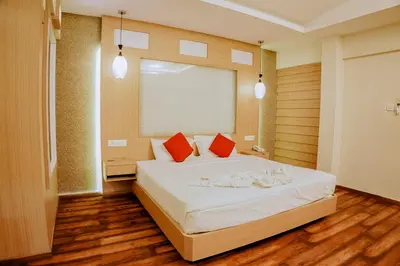 a bedroom with a large white bed with red pillows at Emarald Resort in Pulamanthole