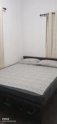 a bed in a room next to a window at family huts in Tariyod
