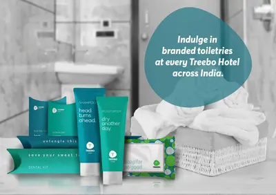 a pile of towels and toiletries in a bathroom at Treebo Durga Boji Grand, Gonikoppal Town in Gonikoppal