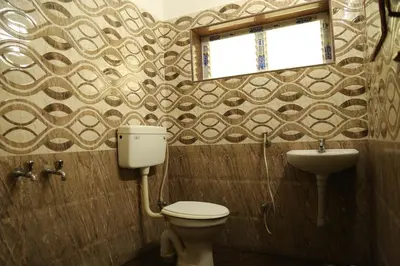 a bathroom with a toilet and a sink at Hotel Vijay in Pollāchi