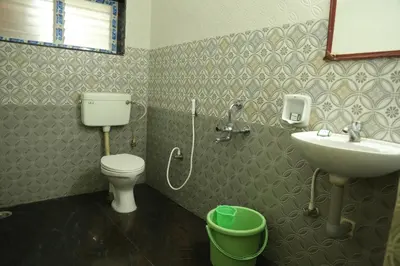 a bathroom with a sink and a toilet and a sink at Hotel Vijay in Pollāchi