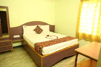 a small room with a bed with a mirror at Hotel Vijay in Pollāchi