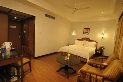a hotel room with a bed and a table at CAG Pride in Coimbatore