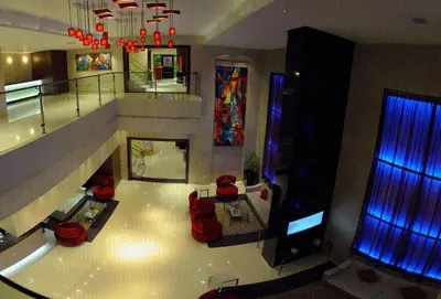 a living room with red chairs and a television at CAG Pride in Coimbatore