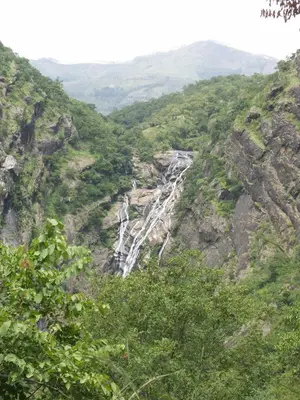 a waterfall on the side of a mountain at Elephant Valley Eco Farm Hotel in Kodaikānāl