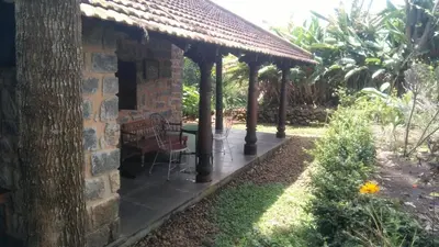 a patio of a house with a table and chairs at Elephant Valley Eco Farm Hotel in Kodaikānāl