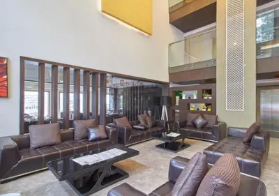 a living room with leather couches and tables at Eastend Munnar in Munnar