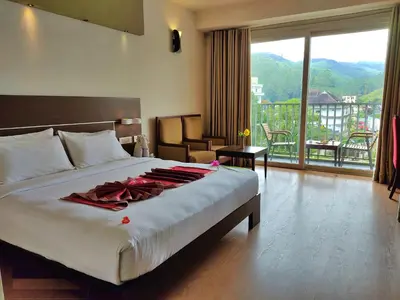 a hotel room with a bed with a robe on it at Eastend Munnar in Munnar
