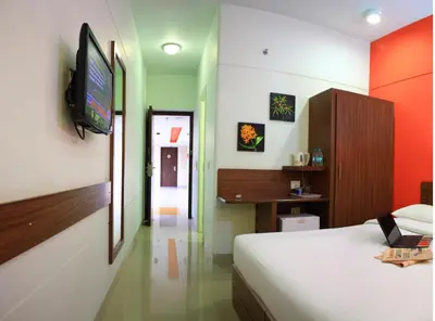 a bedroom with a bed and a television on a wall at Ginger Tirupur in Tiruppūr