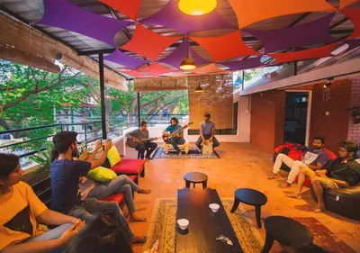 a group of people sitting in a room playing instruments at Zostel Mysore in Mysore