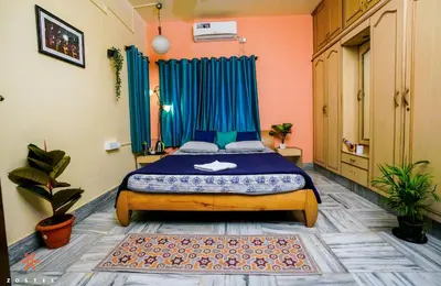 a bedroom with a bed with blue drapes at Zostel Mysore in Mysore