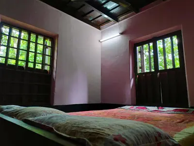 a bedroom with a bed and two windows at Meadows in Trichūr