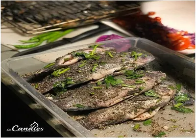 a container of fish with herbs on top of it at Le Candles Resort in Kozhikode