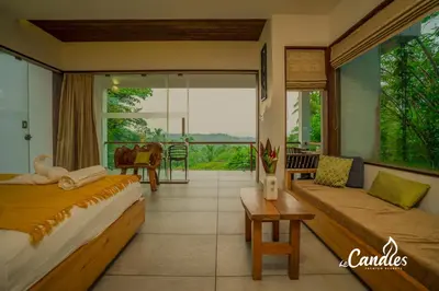 a hotel room with two beds and a balcony at Le Candles Resort in Kozhikode