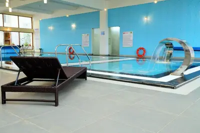 a swimming pool with a chair in front of it at Gem Park Ooty in Ooty