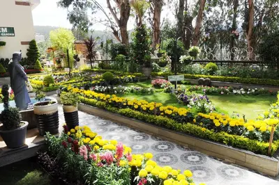 a garden with many flowers in a park at Gem Park Ooty in Ooty