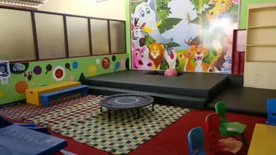 a play room with a couch and a table and chairs at Gem Park Ooty in Ooty