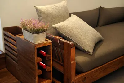 a wooden couch with a potted plant on it at Amanvana Spa Resort, Coorg in Kushālnagar