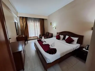 a hotel room with a large bed and a desk at Hotel Preethi Classic Towers in Ooty