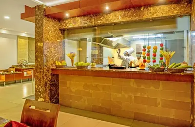 a kitchen with a counter with a chef preparing food at Sterling Ooty Elk Hill in Ooty