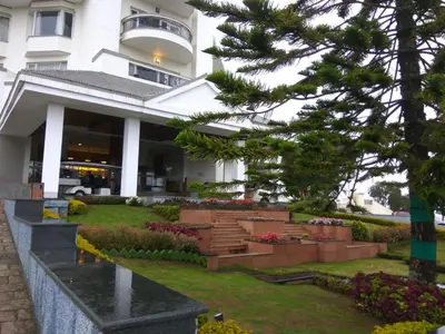 a building with a bunch of flowers in front of it at Sterling Ooty Fern Hill in Ooty
