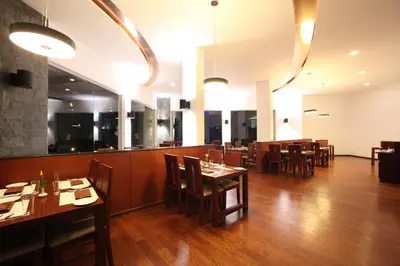 a restaurant with wooden floors and tables and chairs at Sterling Ooty Fern Hill in Ooty