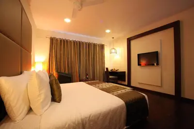 a hotel room with a bed and a television at Sterling Ooty Fern Hill in Ooty