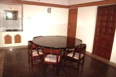 a dining room with a glass table and chairs at Hotel Silver Oak in Ooty
