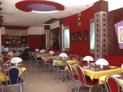 a dining room with tables and chairs and red walls at Hotel Silver Oak in Ooty