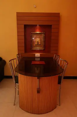 a table in a room with chairs and a picture at Hotel Silver Oak in Ooty