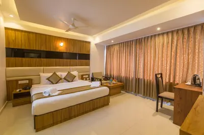 a hotel room with a bed and a desk at Grand Plaza Suites in Kozhikode