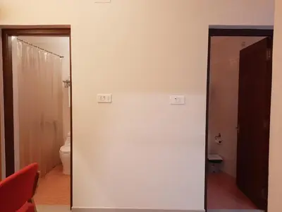 a mirror in a room with a toilet at Meadows Residency in Ooty