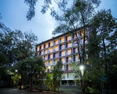 a large building with many windows and trees at Vythiri Village in Vythiri
