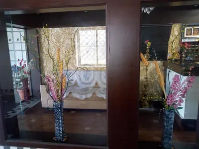 a window in a room with two vases with flowers at Hotel Lovely Nest in Coimbatore