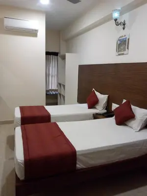 two beds in a hotel room with two beds at Hotel Lovely Nest in Coimbatore